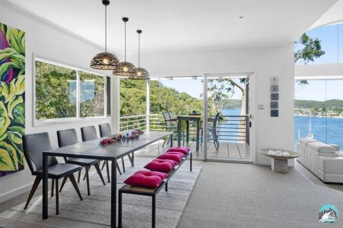 a dining room with a table and chairs at Aircabin - Daleys Point - Waterfront Retreat House in Daleys Point