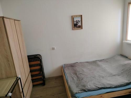 een slaapkamer met een bed en een foto aan de muur bij Leśna Chata kuracyjna z sauną w Borach Tucholskich in Bielska Struga