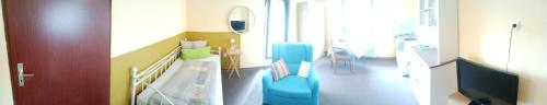 un couloir d'hôpital avec des chaises bleues dans une chambre dans l'établissement Möbliertes Zimmer, à Nuremberg