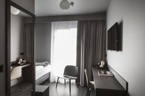 a bedroom with a bed and a desk and a mirror at Skuggi Hotel by Keahotels in Reykjavík