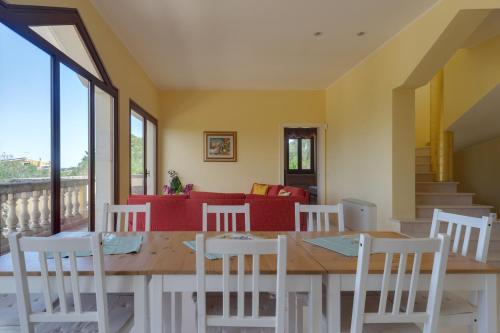 a dining room with a wooden table and white chairs at Relais il Melograno in Arnesano