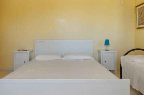 a bedroom with a white bed with two night stands at Relais il Melograno in Arnesano
