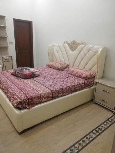 uma cama num quarto com uma cama branca em Sultan Guest House Lahore em Lahore