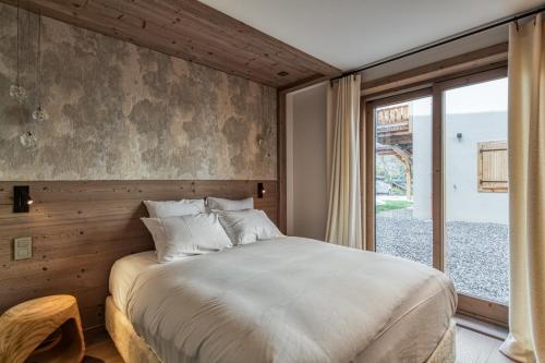 a bedroom with a large bed and a window at Eskape Megève - K3 and Eskape Megève - S2- Happy Rentals in Megève
