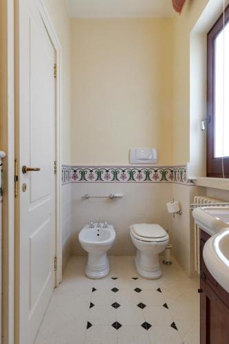 a white bathroom with a toilet and a sink at Relais il Melograno in Arnesano