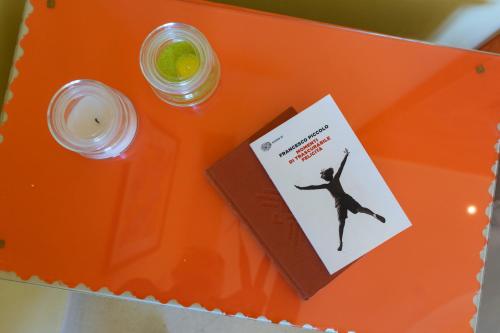 an orange table with a book and a bottle of medicine at Relais il Melograno in Arnesano
