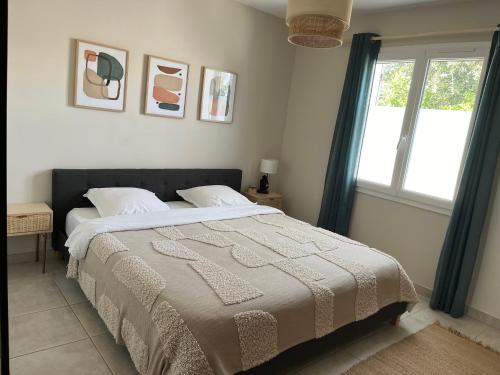 - une chambre avec un grand lit dans une pièce dotée d'une fenêtre dans l'établissement Villa piscine + studio indépendant, à Collias