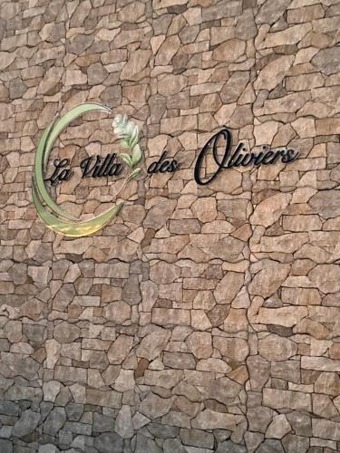 a sign that says be wild as animals on a stone wall at La Villa Des Oliviers chambres d hôtes in Petite Île