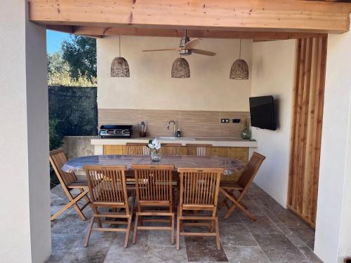 une cuisine et une salle à manger avec une table et des chaises dans l'établissement Villa piscine + studio indépendant, à Collias