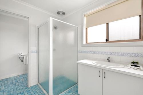 a bathroom with a shower and a sink and a mirror at Marine Cove Resort in Goolwa South