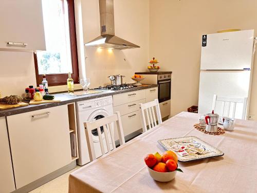a kitchen with a table with a bowl of fruit on it at Relais il Melograno in Arnesano