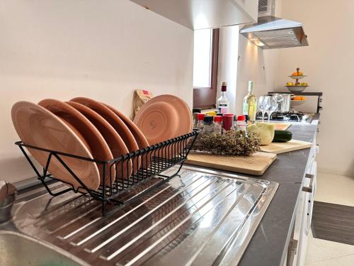 a kitchen with plates in a basket on a counter at Relais il Melograno in Arnesano