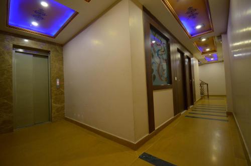 a hallway with a door and blue lights on the ceiling at Umed in Jodhpur