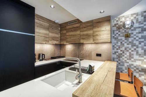 a kitchen with wooden cabinets and a sink at Eskape Megève - K3 and Eskape Megève - S2- Happy Rentals in Megève