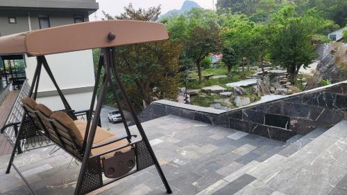 a swing on a balcony overlooking a garden at The Bluestone Lodge in Ha Giang