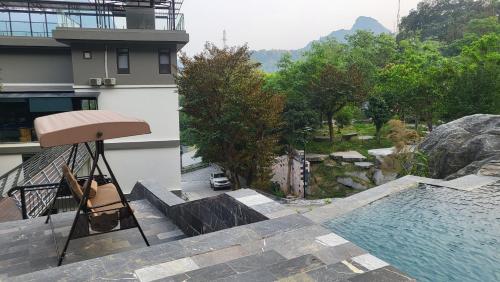 a chair sitting on a balcony next to a swimming pool at Lotus Premium Lodge - Lotus Group Tours in Ha Giang
