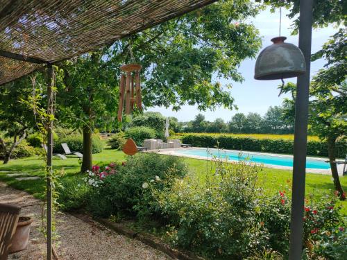 a view of a garden with a swimming pool at Le Vieux Logis de la Galocherie in Sainte-Florence