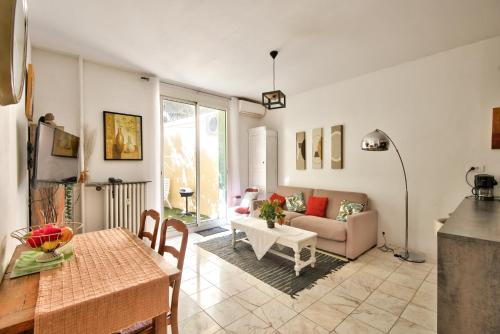 un salon avec un canapé et une table dans l'établissement la palais osiris Nice centre jardin wifi clim parking, à Nice