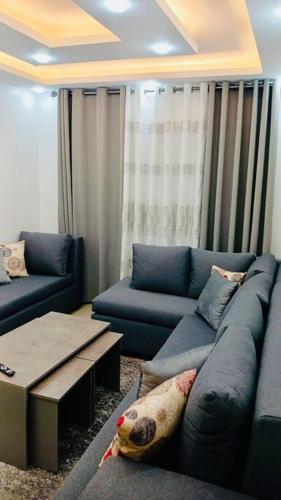 sala de estar con sofá azul y mesa en شقة فندقية فاخرة - غرفتا نوم - تلاع العلي en Umm Uthainah