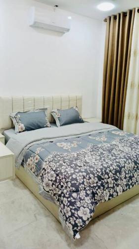 a bedroom with a bed with a blue comforter at شقة فندقية فاخرة - غرفتا نوم - تلاع العلي in Umm Uthainah