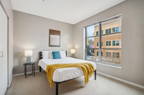 a bedroom with a bed and a large window at CozySuites 2BR Mill District with pool, gym #04 in Minneapolis
