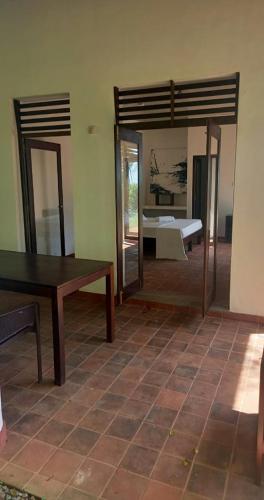 a room with a bed and a table and mirror at Bluewind Resort in Tangalle