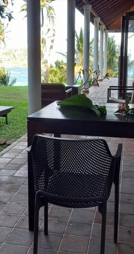 a table with a chair sitting on a patio at Bluewind Resort in Tangalle