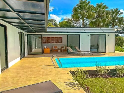 una casa con piscina en una terraza de madera en Modern Home with Panoramic Ocean View and Pool, en Ojochal