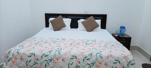 Murli Manohar Palace في فريندافان: غرفة نوم بسرير كبير ومفرش من الزهور
