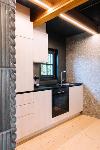 a kitchen with white cabinets and a black counter top at SCHILCHERLANDLEBEN - Weingartenhaus in Sankt Stefan ob Stainz