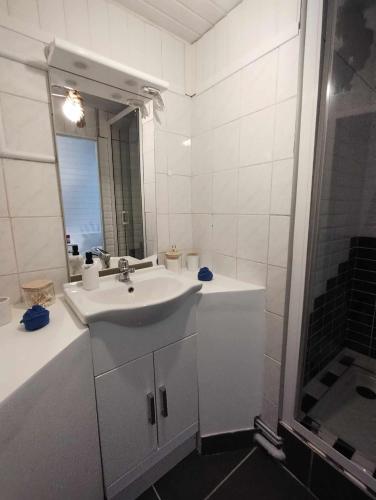 a white bathroom with a sink and a shower at Maison de campagne in Rieux-Minervois