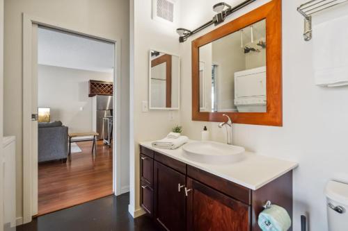 La salle de bains est pourvue d'un lavabo et d'un miroir. dans l'établissement Two CozySuites Mill District #04 & 01, à Minneapolis