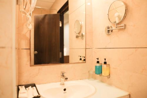 a bathroom with a sink and a mirror at Happy Stays Whitefield in Bengaluru