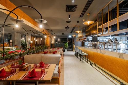 a restaurant with tables and chairs and a bar at La Green Hotel and Residence in Bang Tao Beach