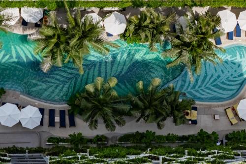 an aerial view of a resort swimming pool with palm trees at La Green Hotel and Residence in Bang Tao Beach