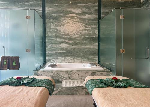 a bathroom with two beds and a bath tub at La Green Hotel and Residence in Bang Tao Beach