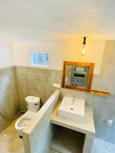 a bathroom with a sink and a toilet at Rivinu Place Arugambay in Arugam Bay