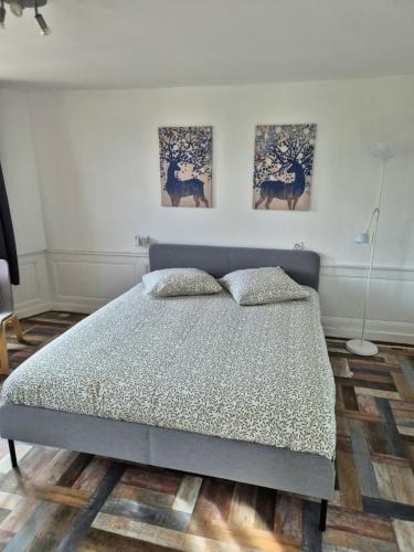 1 dormitorio con 1 cama y 3 cuadros en la pared en La Brionnaise Studio, en Brionne