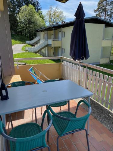 un tavolo e due sedie e un ombrellone su un patio di Ferienwohnung Seeluft a Keutschach am See