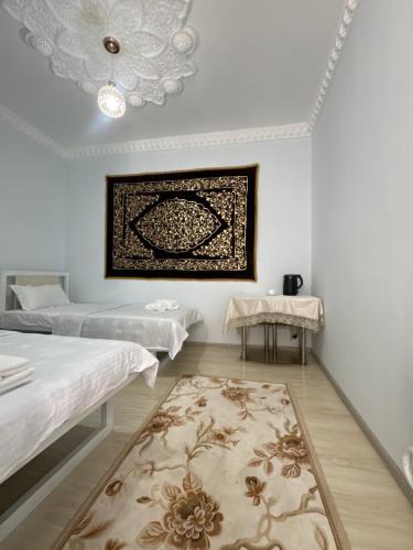 a room with two beds and a rug at Boulevard in Bukhara