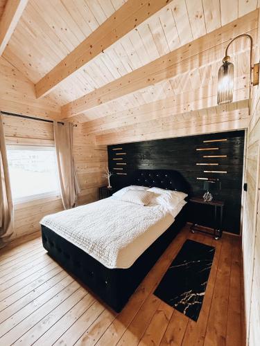 a bedroom with a large bed in a wooden room at Parkowy Kudowa in Kudowa-Zdrój