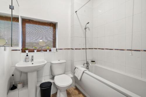 een witte badkamer met een toilet en een wastafel bij Livestay - Two Bed London Apt with Balcony in Colindale