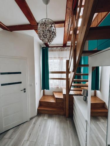 a room with wooden floors and a ceiling with a chandelier at Parkowy Kudowa in Kudowa-Zdrój