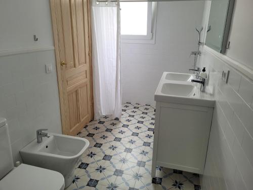 uma casa de banho branca com 2 lavatórios e um WC em Casa con WiFi, patio y garaje privado em Alcalá de Guadaíra