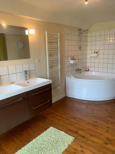 une salle de bain avec deux lavabos et une baignoire dans l'établissement Maison à louer, à Noron-la-Poterie