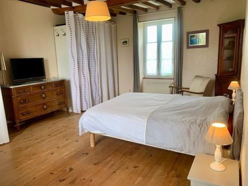 1 dormitorio con 1 cama blanca y TV en Maison à louer, en Noron-la-Poterie