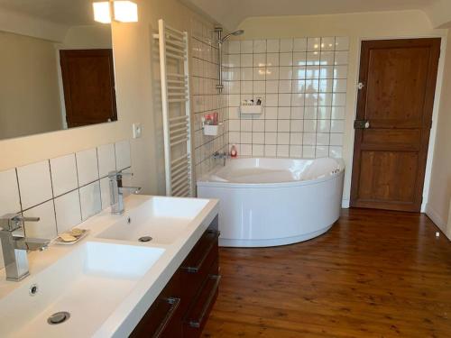 baño con 2 lavabos y bañera grande en Maison à louer, en Noron-la-Poterie