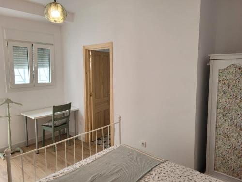 um quarto com uma cama, uma secretária e uma mesa em Casa con WiFi, patio y garaje privado em Alcalá de Guadaíra