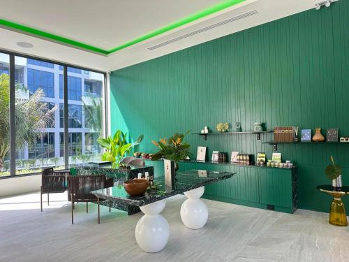 a room with green walls and a table and chairs at La Green Hotel and Residence in Bang Tao Beach