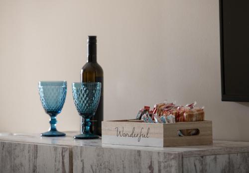 a bottle of wine and two wine glasses on a table at StayInn Luxury Apartments in Nea Kalikratia